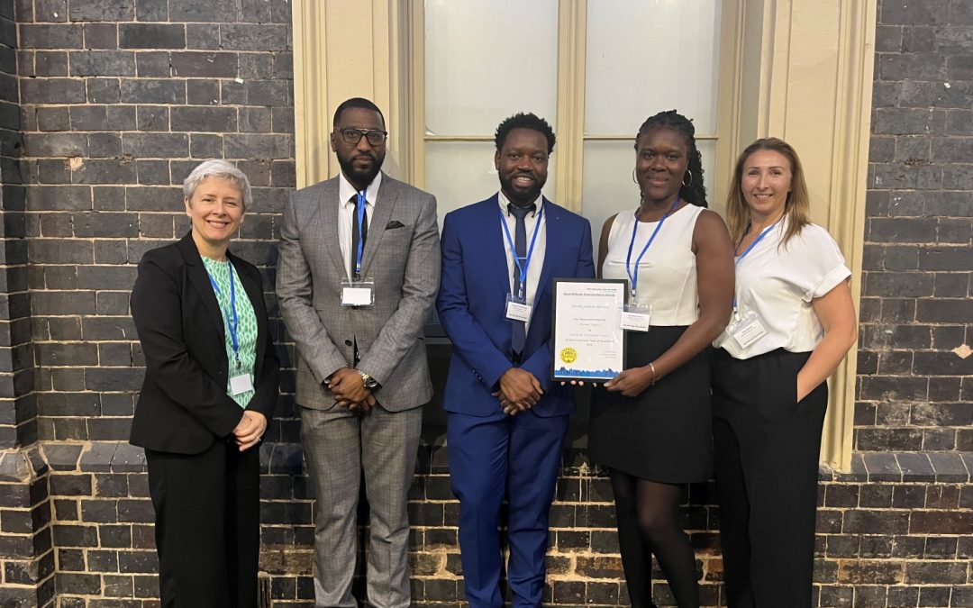 The team standing with award